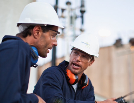 Two people talking outside factory