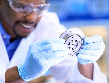 Person with gloves looking at machine part