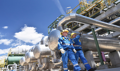 Two people walking beside a big machine