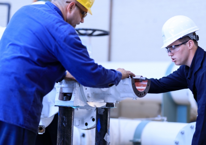 People working over large pipe